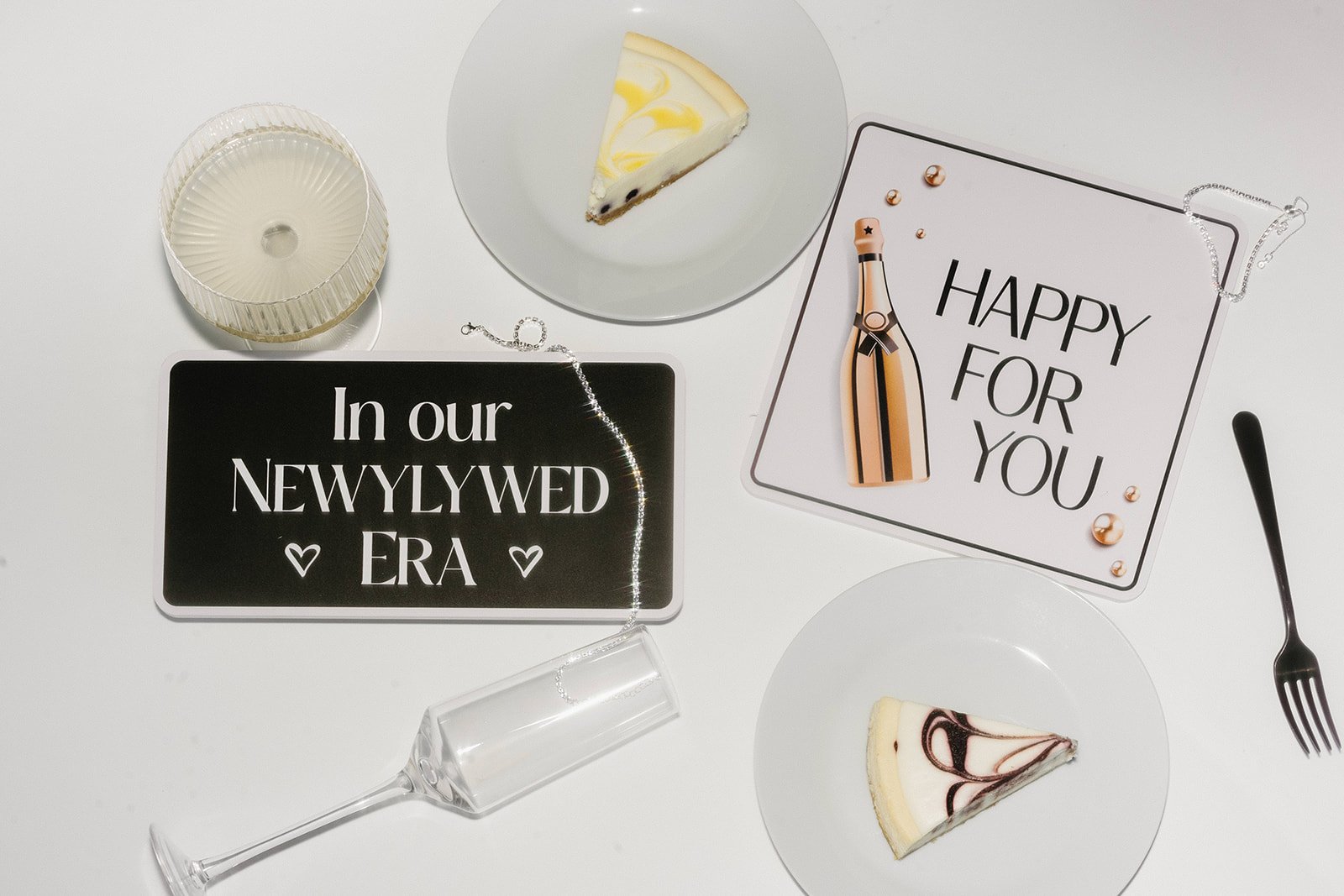 Cards reading In our Newlywed Era and Happy for you beside a slice of cake
