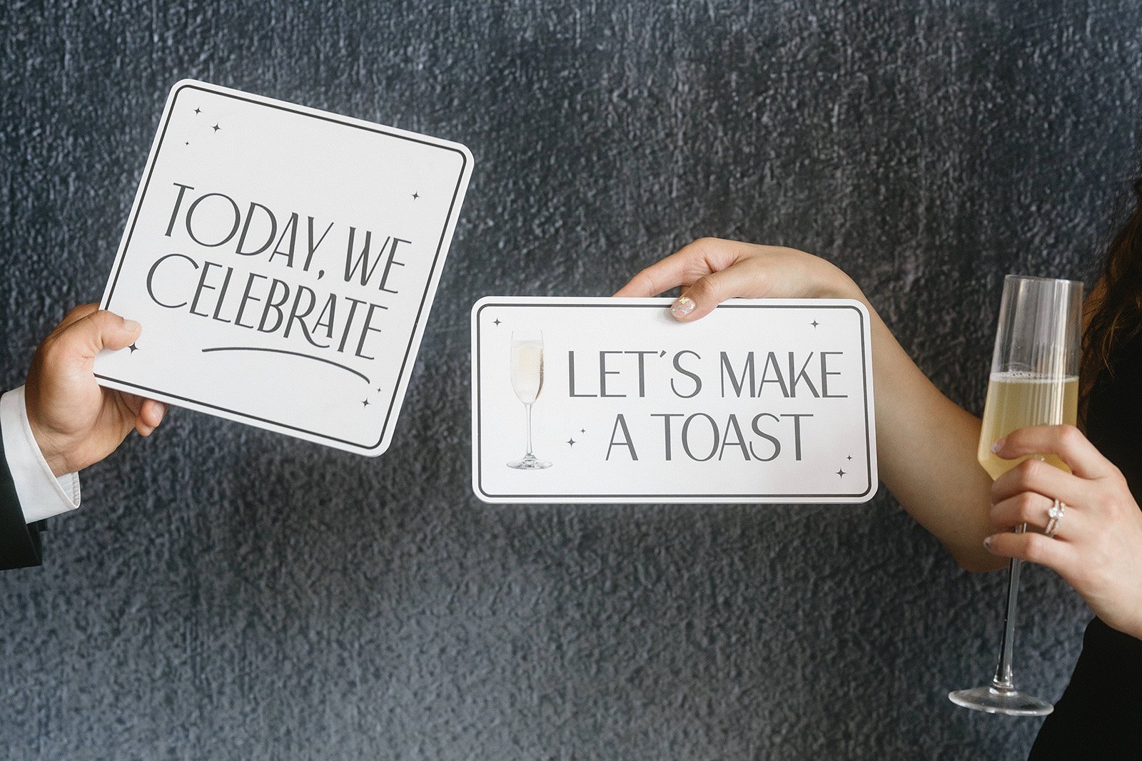 Cards reading Today we celebrate and Let’s make a toast beside a glass of champagne