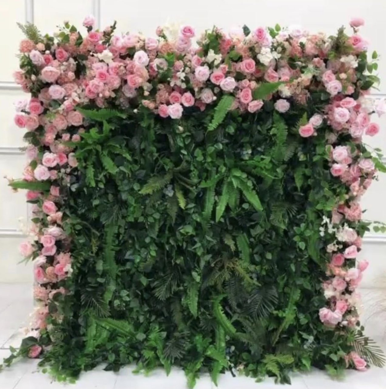 The Flamingo flower wall: pink roses over layered ferns and greenery