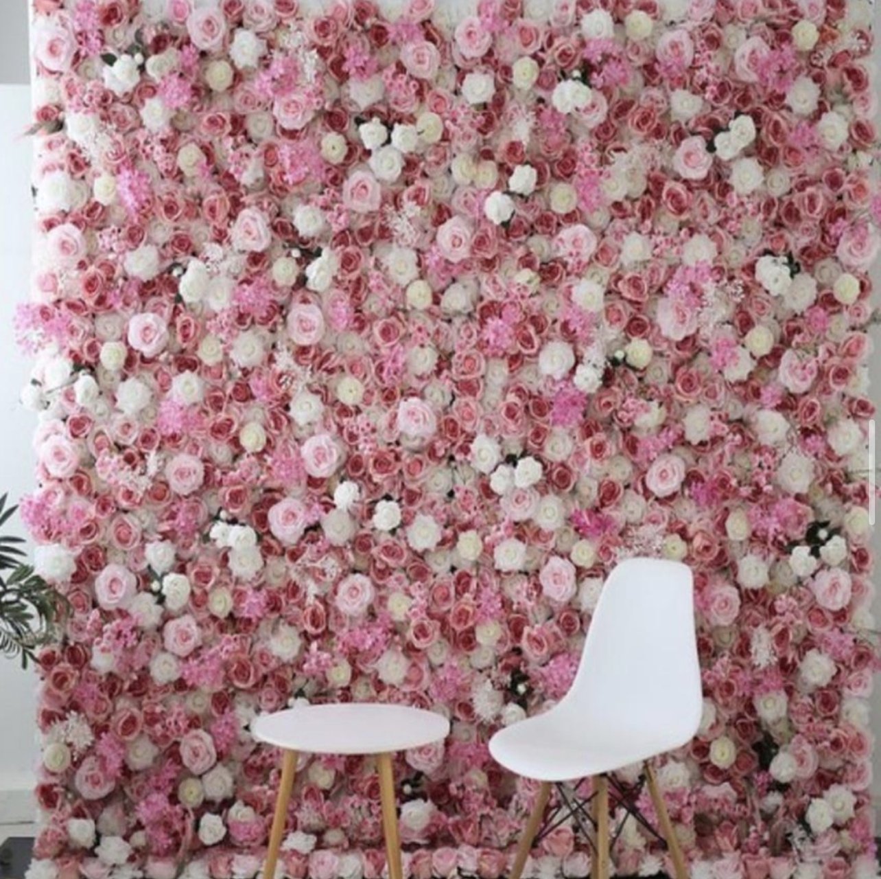 The Mimi flower wall: pink and blush roses, with a white chair and a small white table